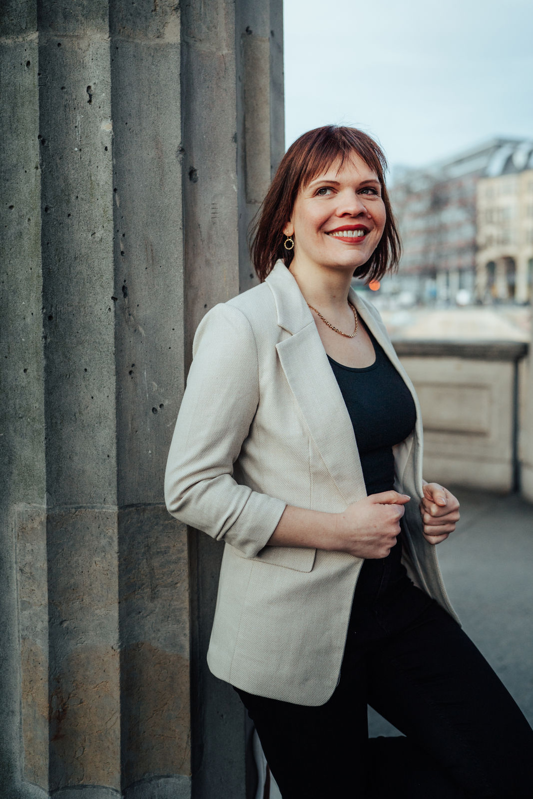 Frau in eleganter Kleidung, urbanes Umfeld.